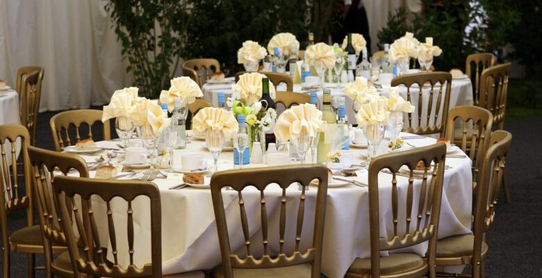 Eleganckie krzesła cateringowe stoją przy okrągłym stole w sali